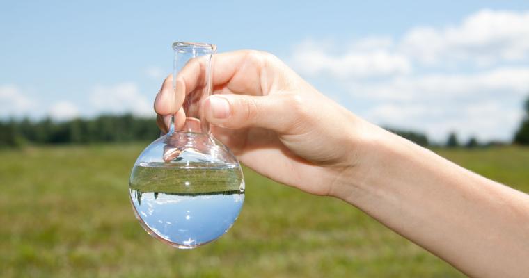 Decoratief: hand houdt een reageerbuisje vast